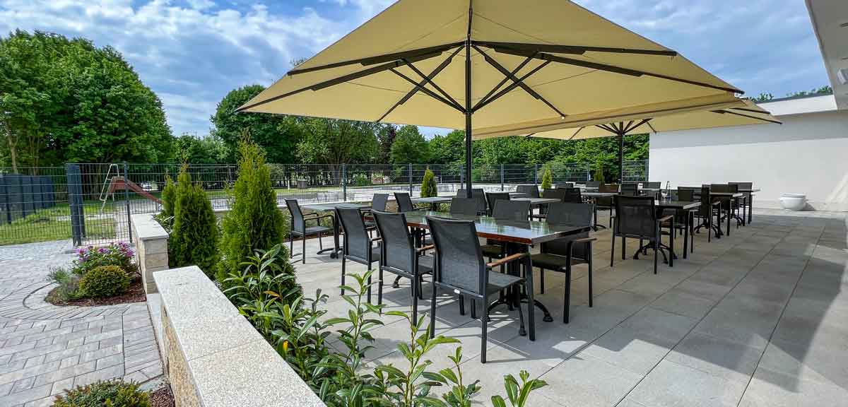 Überdachte Terrasse mit Spezialitäten und weitläufigem Resort